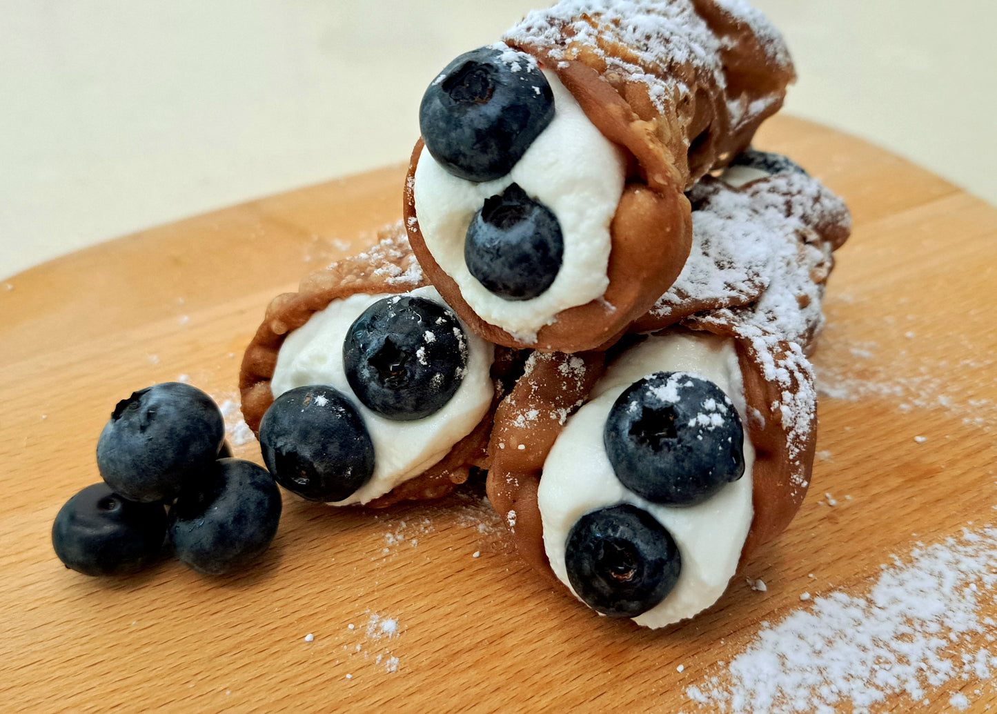 Deep fried cannoli shells, filled with both blueberry jam and ricotta cream. End topped with juicy and sweet blueberries and finished off with powdered icing sugar.
