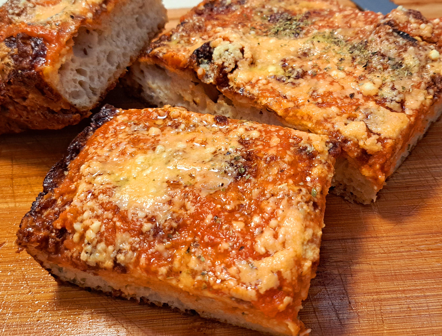 Detroit-style pizza is a unique and delicious variation of pizza that originated in Detroit, Michigan. Characterized by its rectangular shape and a thick, airy crust that is crispy on the outside and soft on the inside. Sauce is usually a chunky tomato sauce, often seasoned with herbs and spices. It can be applied in a "racing stripe" pattern over the cheese and toppings or served on the side for dipping