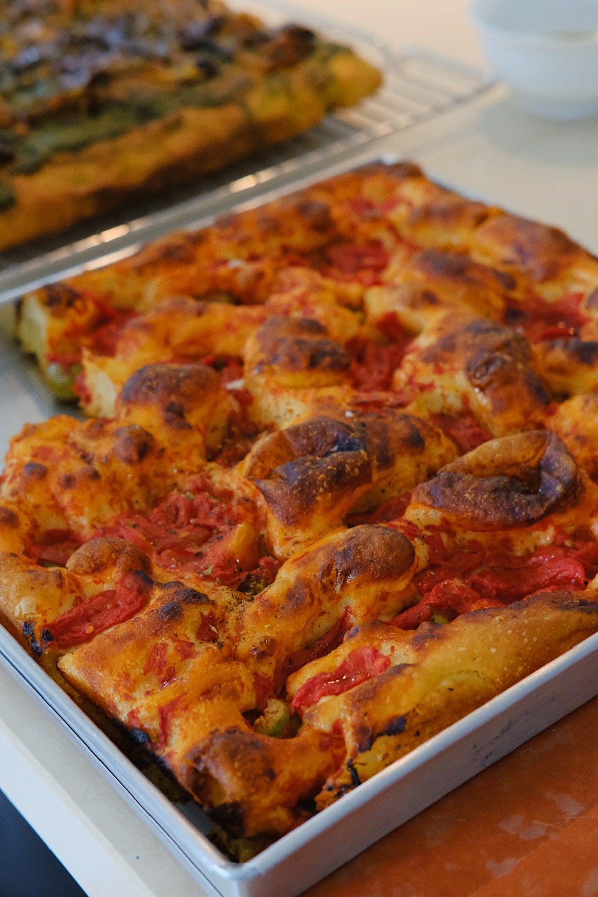Focaccia Barese is a traditional Italian bread originating from Bari. It has a soft, airy interior with a slightly crispy crust. The dough is often quite moist, contributing to its delightful chewiness. topped with a generous amount of cherry tomatoes, olives, and sometimes herbs like rosemary. The toppings are pressed into the dough, allowing their flavors to infuse during baking.