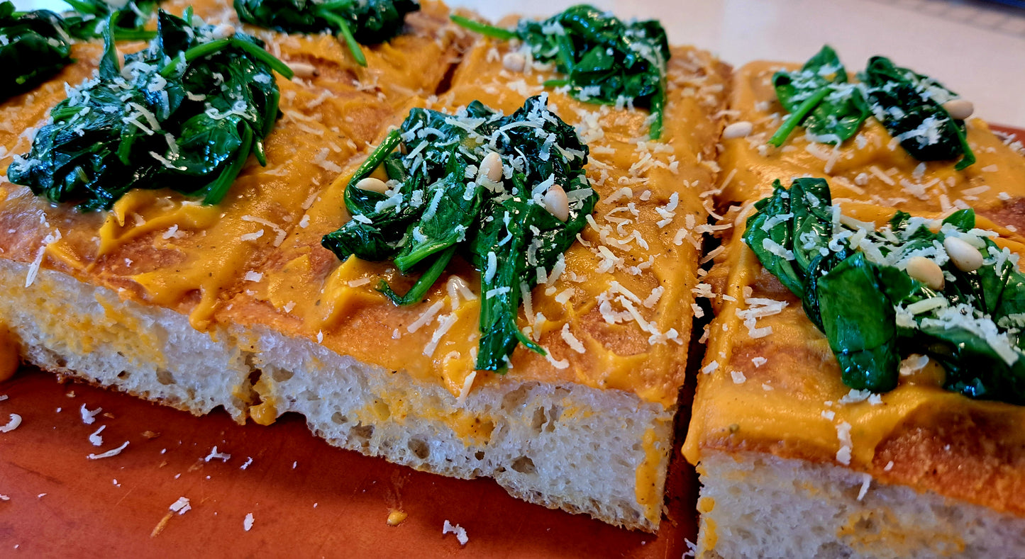 Pumpkin focaccia topped with spinach, shredded parmesan and roasted pine nuts.