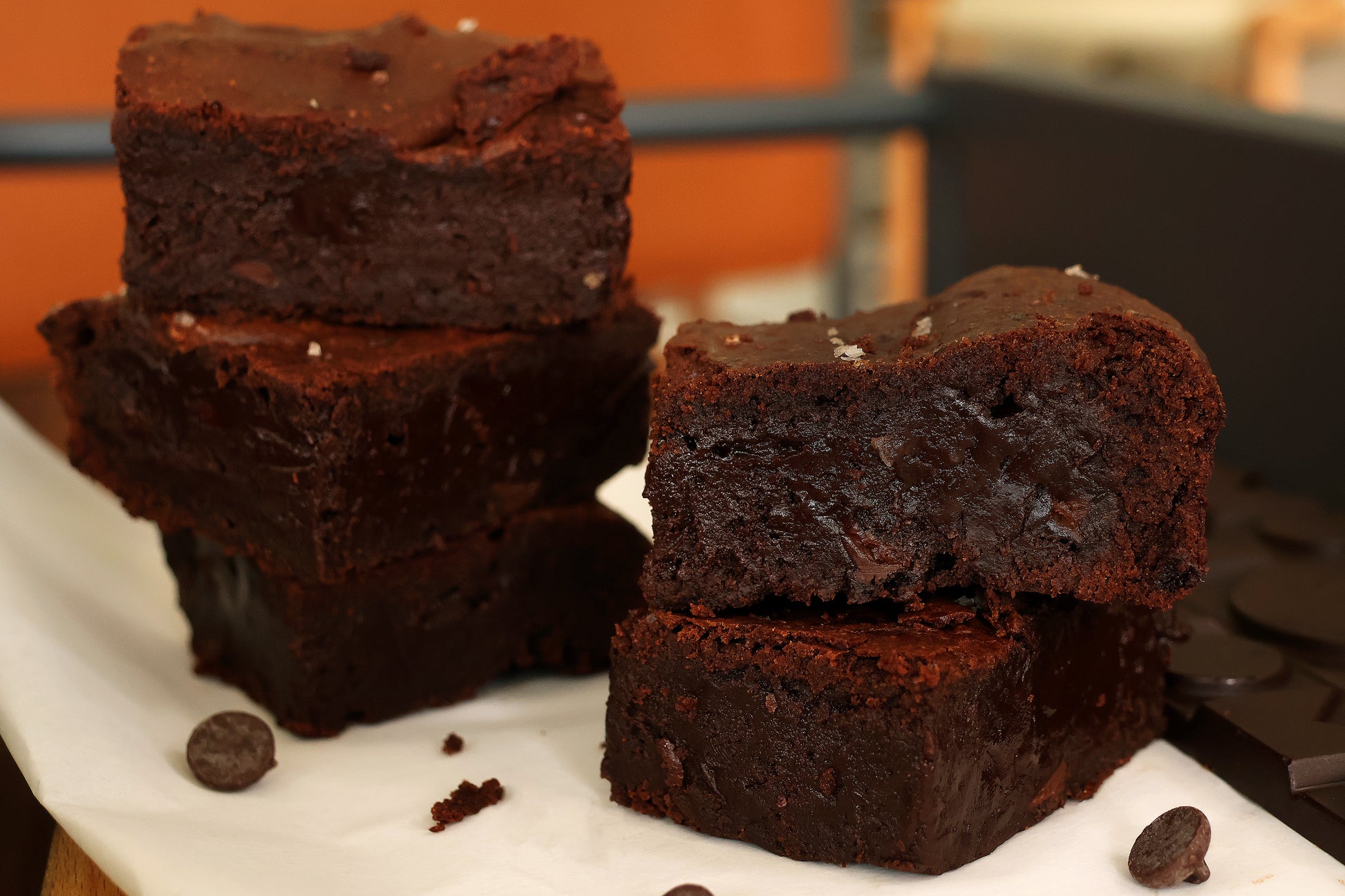 Cross section of fudgy sea salt brownies, filled with dark chocolate chips.