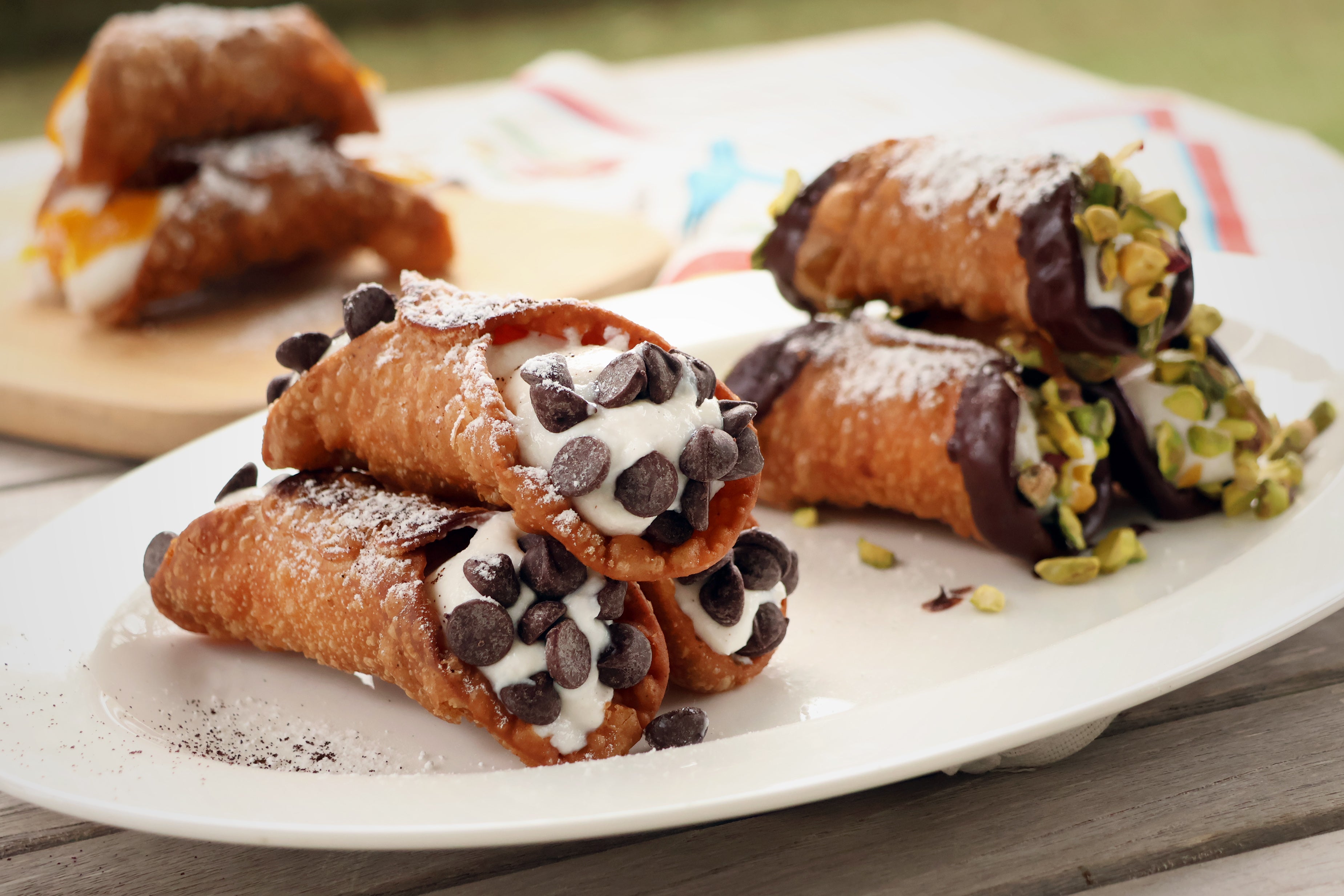 Deep Fried Cannoli. All filled with ricotta cream and dusted with icing sugar. Flavours include orange, pistachio and chocolate